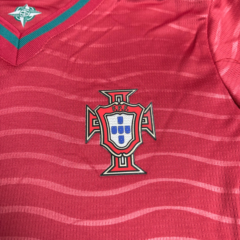 Kit Infantil Portugal I 2026/27 Manga Longa Vermelho Camisa e Shorts - detalhe do escudo bordado