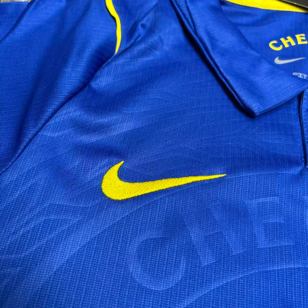 Kit Infantil Chelsea I 2026/27 Azul Camisa e Shorts - detalhe do logo do fornecedor