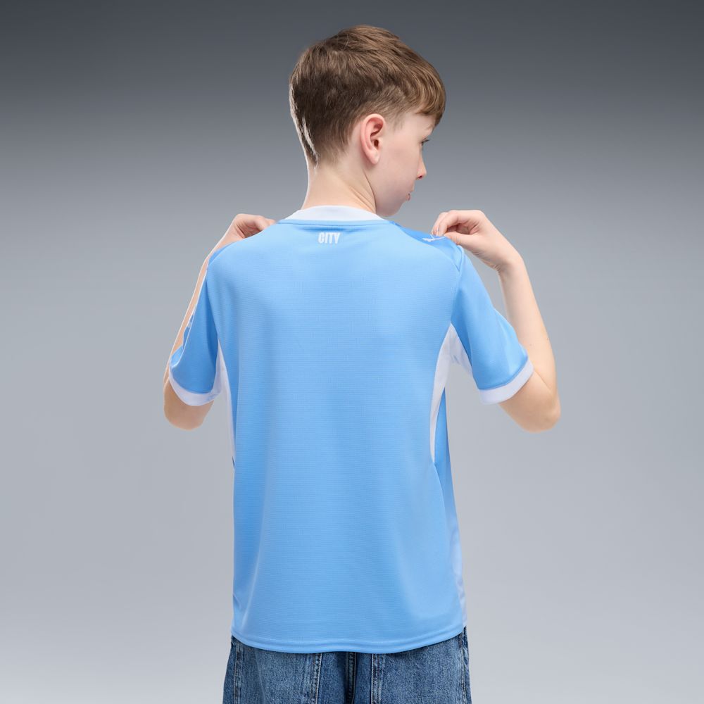 Kit Infantil Manchester City I 2026/27 Azul-Celeste Camisa e Shorts - criança vestindo o kit, vista de costas