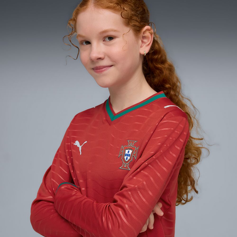 Kit Infantil Portugal I 2026/27 Manga Longa Vermelho Camisa e Shorts - criança vestindo a camisa, detalhe do peito
