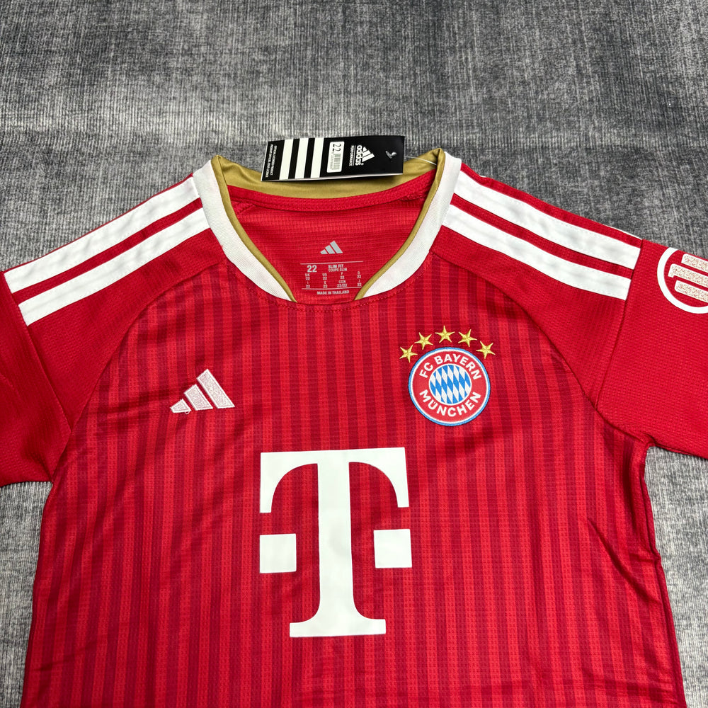 Kit Infantil Bayern de Munique I 2026/27 Vermelho Camisa e Shorts - detalhe do peito