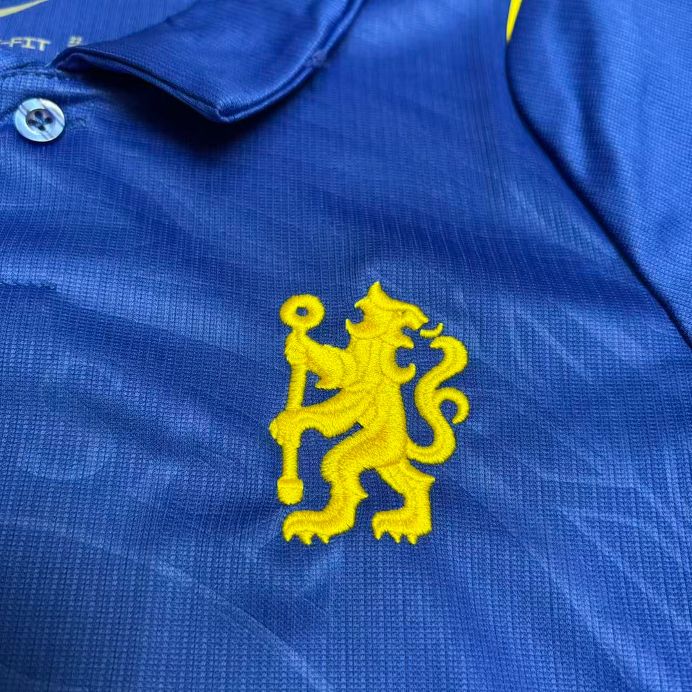 Kit Infantil Chelsea I 2026/27 Azul Camisa e Shorts - detalhe do escudo bordado