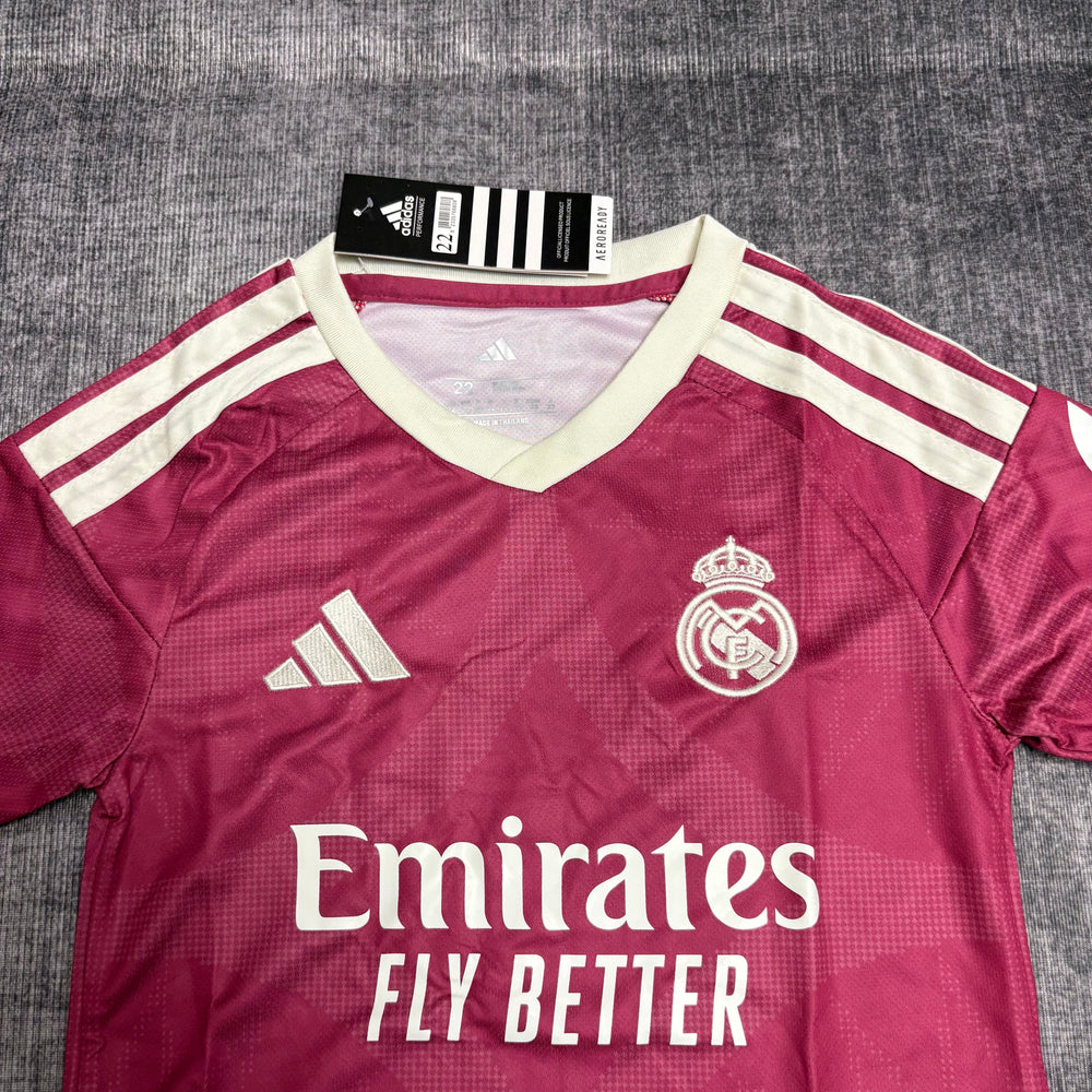 Kit Infantil Real Madrid III 2026/27 Rosa Camisa e Shorts - detalhe do peito